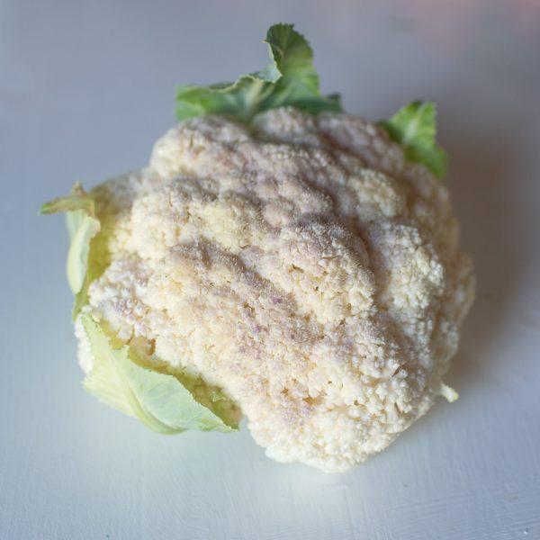 organic cauliflower head on a white table