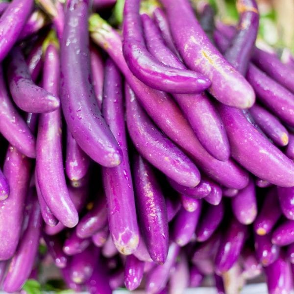 Pile of beautiful light purple eggplants that are slim and long in shape