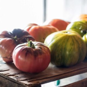 a variety of heirloom tomatoes on a wooden box